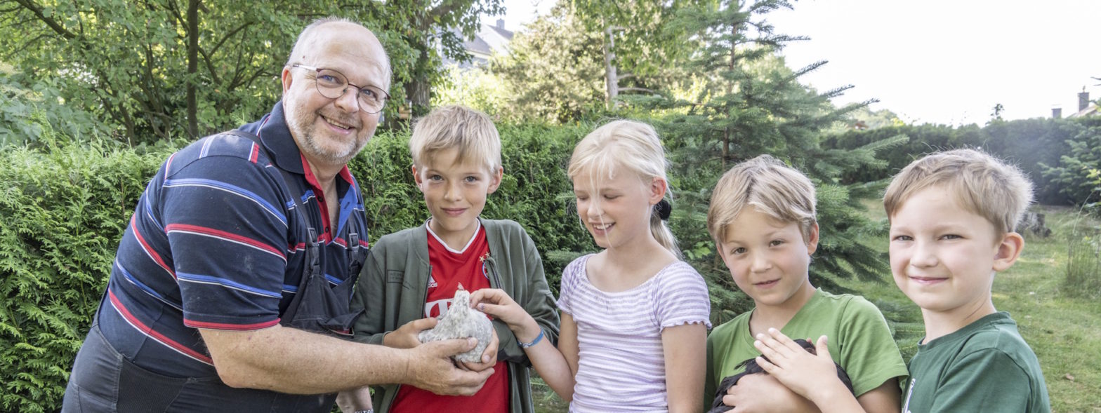 Hausmeister Fred Manhold mit Kindern und Hühnern