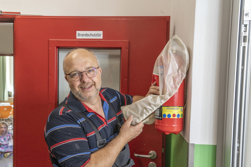 Hausmeister Fred Manhold prüft Feuerlöscher