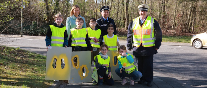 Gruppenfoto: Schülerinnen und Schüler halten Schablone vom Präventionsprojekt "Gelbe Füße"