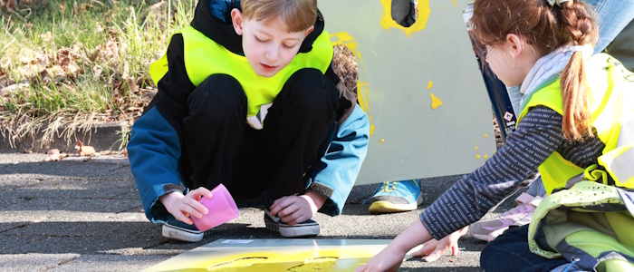 Ein Junge trägt Granulat auf eine Markierung auf.